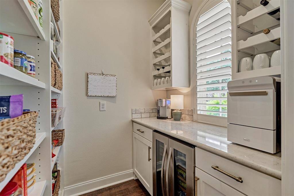 Pocket door to walk-in pantry with dedicated wine storage & built-in wine fridge.
