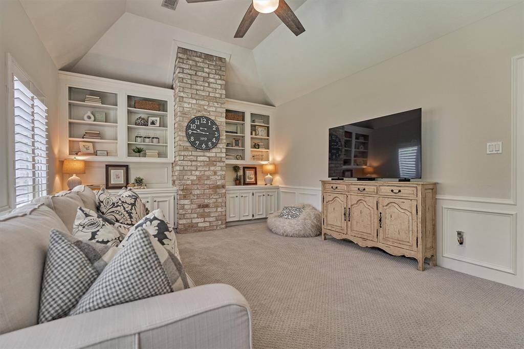 Game room upstairs with brick accent column and built-in shelves and storage.