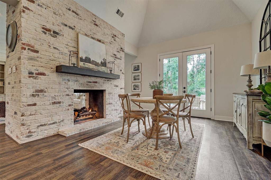Cozy breakfast room features a rustic brick double-sided fireplace.