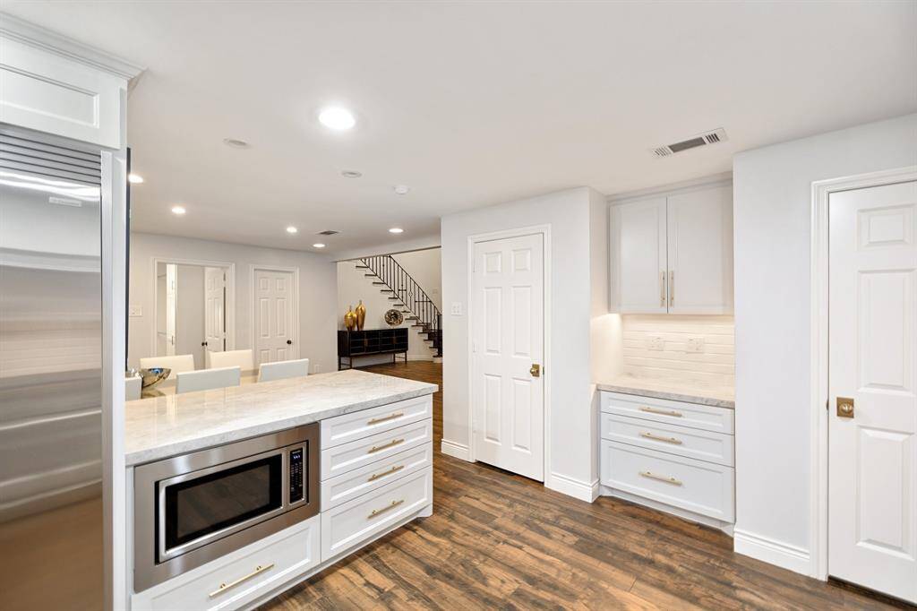A view of the Kitchen (20 x 12) toward the Breakfast Room (13 x 11) showing the peninsula with the microwave below and the 2-reach in pantries with counter in between ideal for a coffee bar or a toaster!  Beautiful finishes.