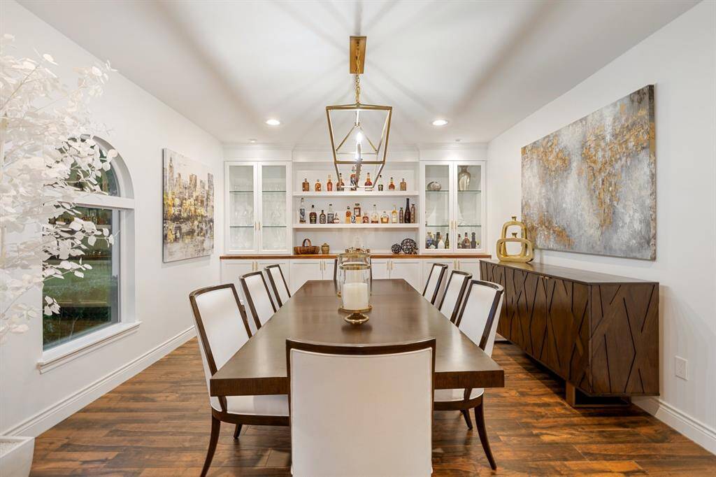 The banquet sized Dining Room (20 x 13) standouts include the porcelain tile wood style flooring, built-in buffet with glass front upper cabinets and solid wood lower cabinet doors, caged chandelier and arched window overlooking the front yard.  Access to the Entry and Kitchen.