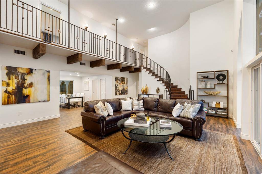 The 2-story Family Room (22 x 21) as viewed toward the sweeping staircase.  At the top of the stairs to the right is the paneled Game Room or Study and straight ahead is the study with 2 closets leading to the Primary Bedroom with 2-reach in closets and a large walk-in closet.  Crisp and clean describes the incredible living spaces in this wonderful home.  The 2-closed doors downstairs lead to the Powder Bath (right door) and the expanded Utility Room (left door). The first floor is bathed in natural light.
