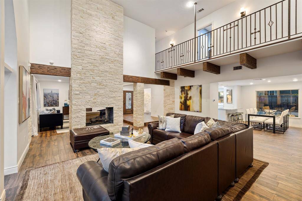 The 2-story Family Room (22 x 21) opens to the Living Room (17 x 14) on the other side of the fireplace, the Breakfast Room (13 x 11) and Kitchen (20 x 12) through the large cased opening and the Dining Room (20 x 13) to the right of the Entry at the far end of the image.  The "catwalk" upstairs connects the 3-secondary bedrooms to the Primary Suite (bedroom and study) and the other Study/Game Room.  Great space at every turn in this very fine home.