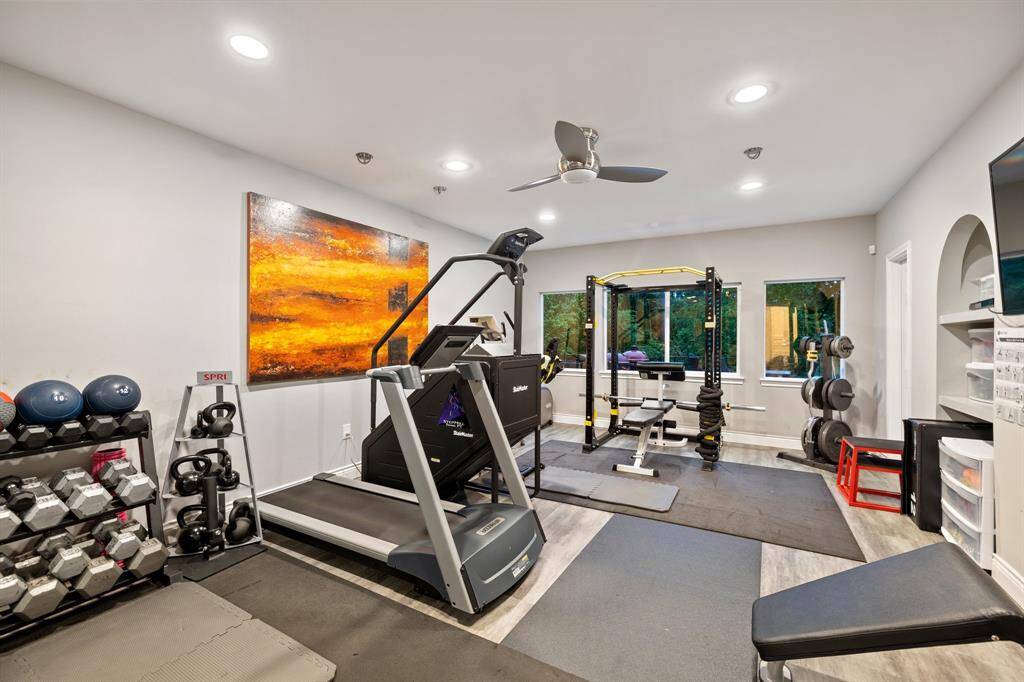 The gym (21 x 14 or Bedroom 5) is located on the first floor and has an en suite bath. Standouts include Coretec flooring, mirrored accent wall, large walk in closet in the room and in the bathroom, en suite bath, built-in TRX /punching bag.  This is the "real deal".  Windows overlooking the outdoor dining area which leads down to the terraced yard to the bayou.