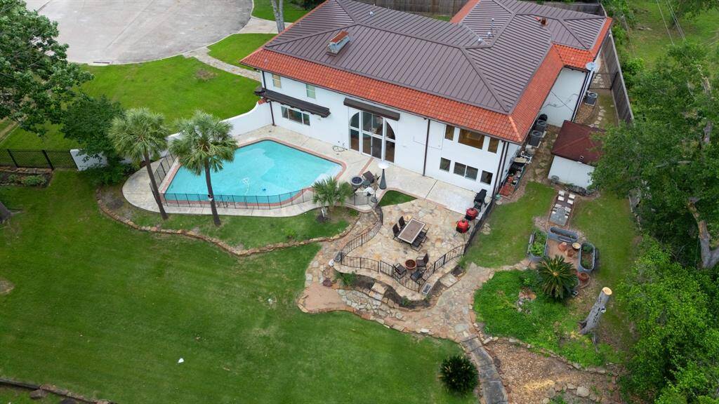 This drone image shows the swimming pool (removable gate), the flagstone patio, the large terraced yard and the large additional yard used for a vegetable and herb garden and a built-in smoker.