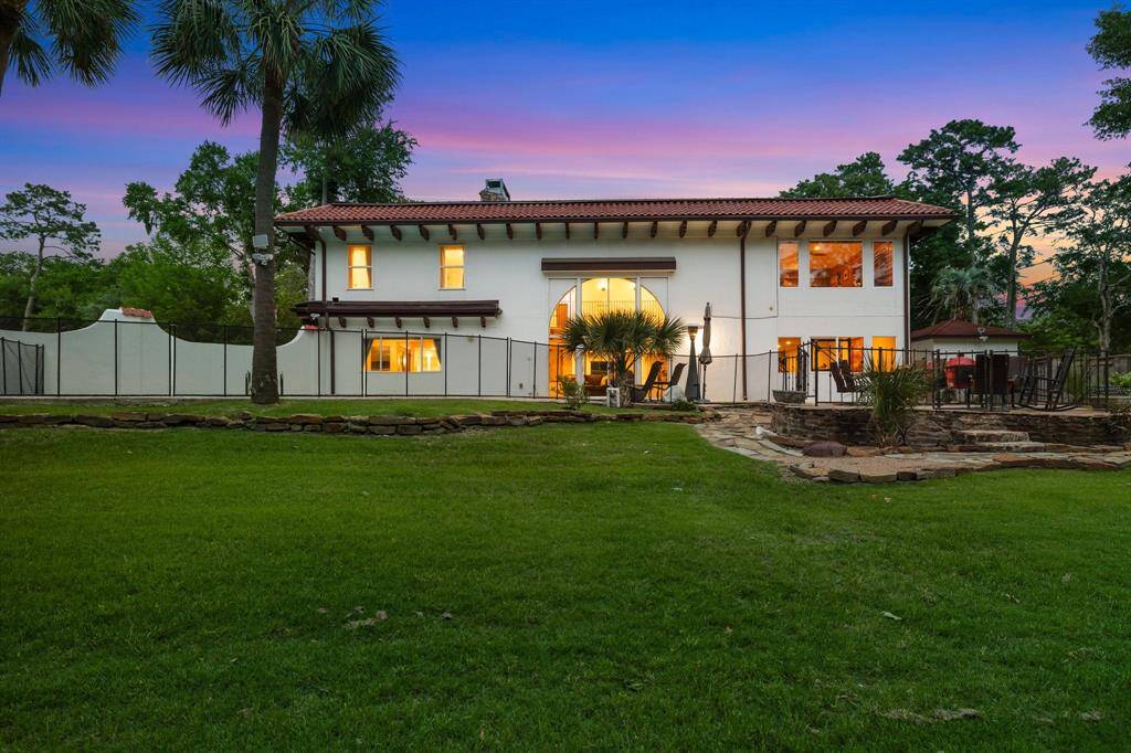The rear elevation of this outstanding property showing the gated swimming pool, the vast flagstone patio, Bedroom windows (upper left), Living Room windows (lower left), fabulous arched window with storm shutter, gym/BR5 windows lower right and Game Room (currently used as a Study) upper right. Look at this amazing yard in this 36,250 SF/HCAD lot.