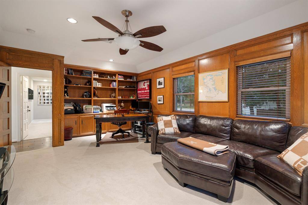 A view of the Game Room/Study (21 x 14) focusing  on the wall of built-in bookcases, paneled walls, numerous windows, recessed lighting and ceiling fan.  There is a large walk-in closet out of view. Great flexible space on the second floor.