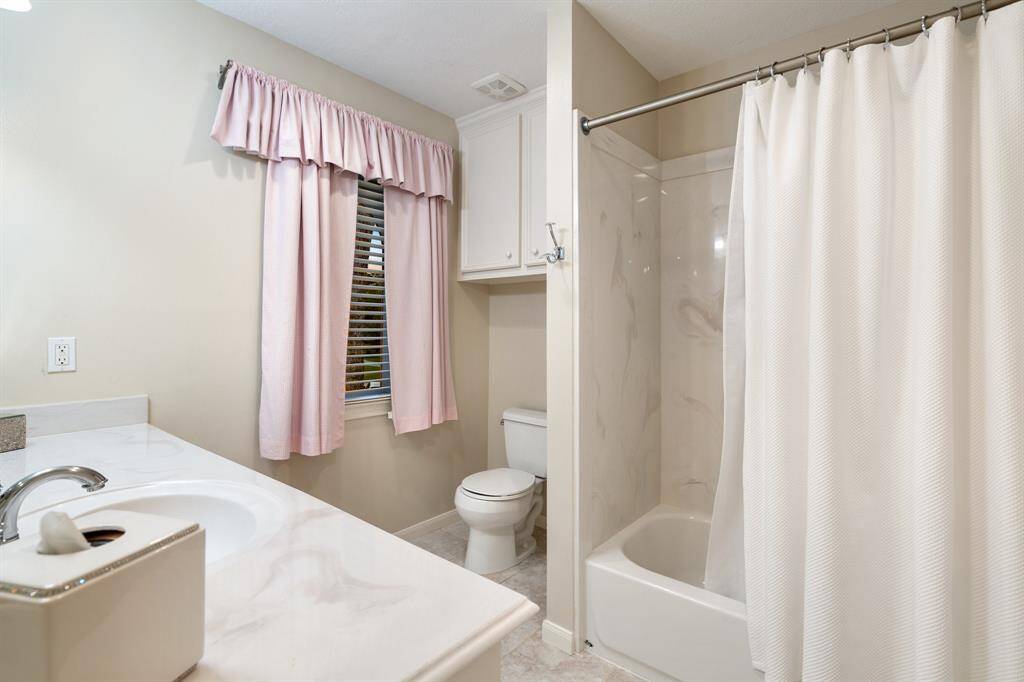 This is the en suite bath to a secondary bedroom (13 x 13) with tub/shower, privacy wall to the toilet and large vanity. Great bedroom with en suite bath.