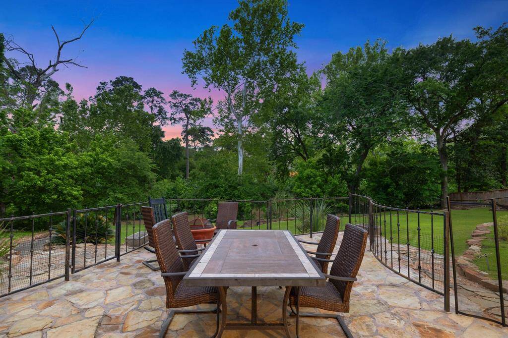 A close up image of the outside dining area on the flagstone patio.  The backyard in this oversized 36,250 SF LOT/HCAD that is terraced from the swimming pool to the bayou.  Plenty of space for pets and children alike. Great area for "al fresco" dining.