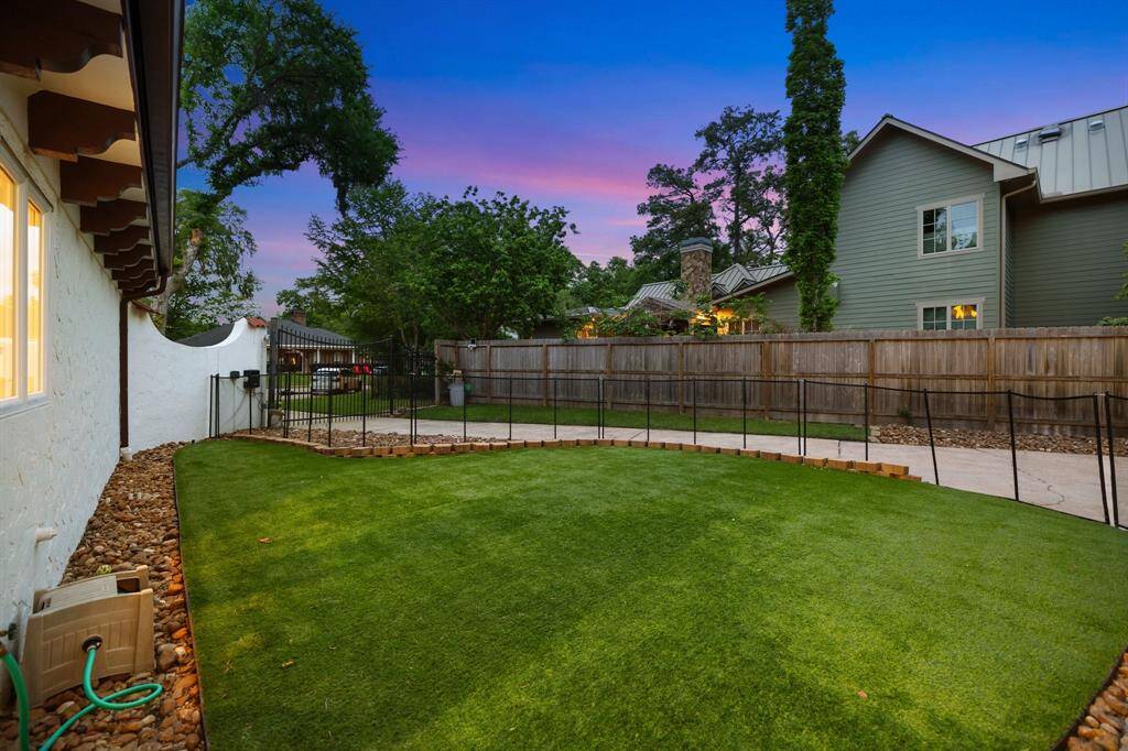The turfed side yard off the covered loggia off the gated driveway.  Great for pets or young children to be separate from the swimming pool and bayou.