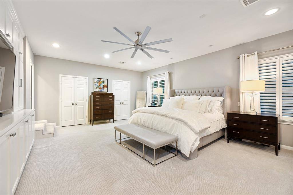 A view of the Primary Bedroom (24 x 16) highlighting the 2-windows with Plantation shutters, recessed lighting and ceiling fan.  The 2-steps lead to the beautiful and timeless Primary Bath!