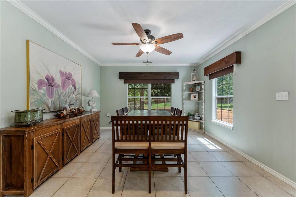 Elegant formal dining room with large windows overlooking the scenic property.