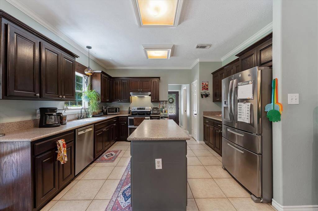 Spacious kitchen with stainless steel appliances and ample counter space for meal prep.