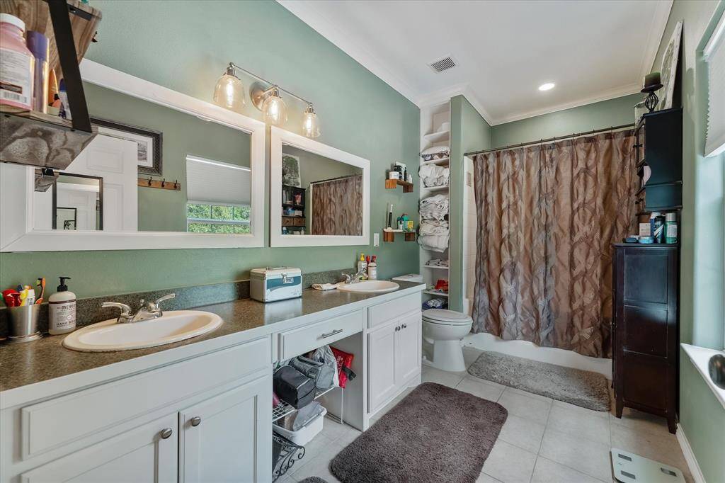 Primary bath with dual sinks, updated fixtures and new toilet.