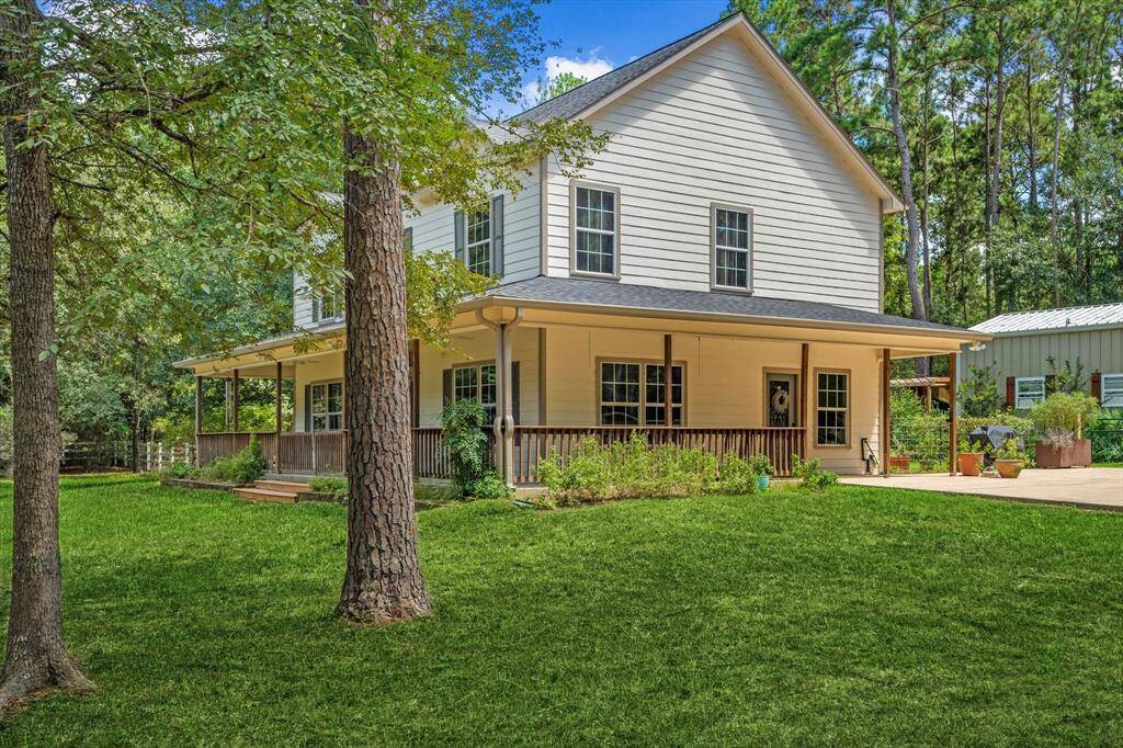 Expansive yard surrounded by mature trees, offering a warm and inviting entrance.