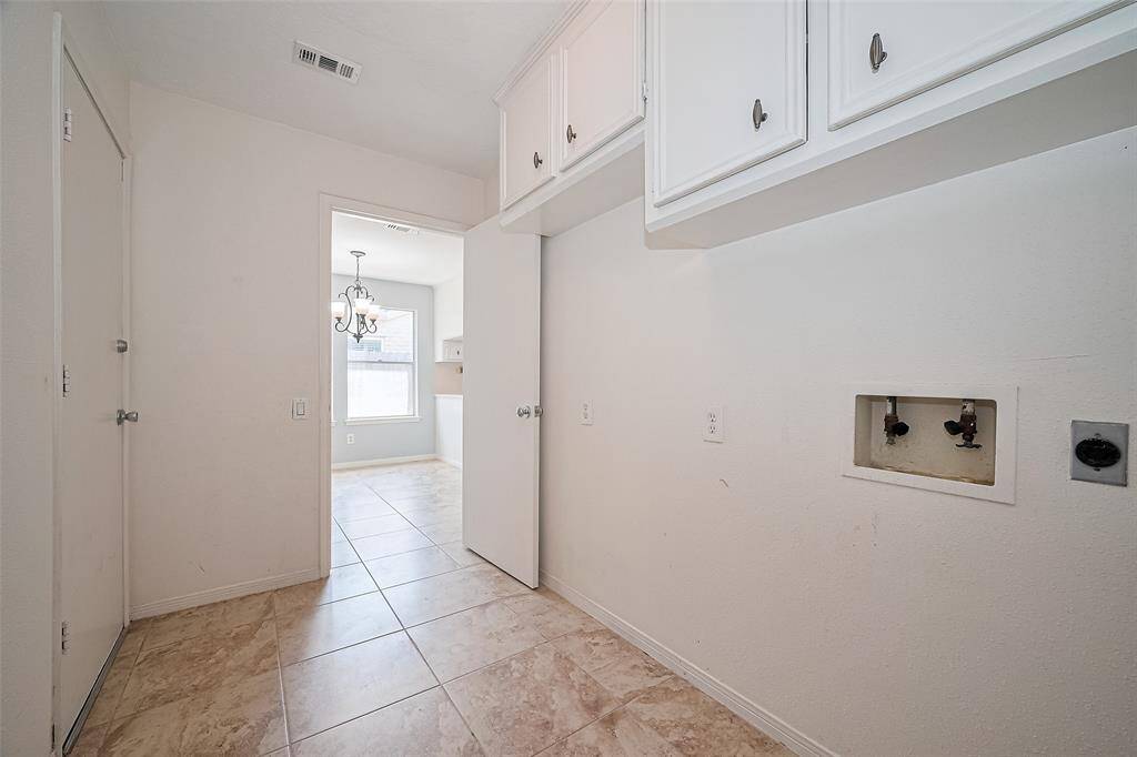 Laundry room in the home connecting the kitchen area to the garage.