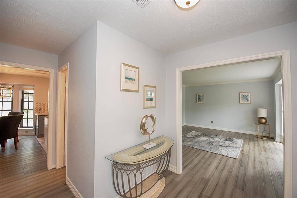 A view of the foyer with each access to the formal areas as well as the kitchen and family room.