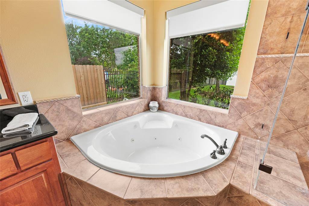 Primary bathroom featuring large corner jetted tub.