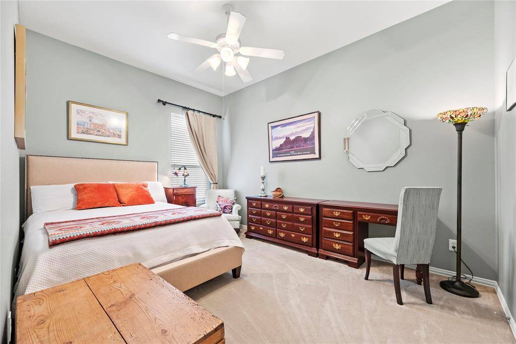 Third bedroom features a ceiling fan, ample natural light from a window with blinds and curtains, and a carpet flooring.