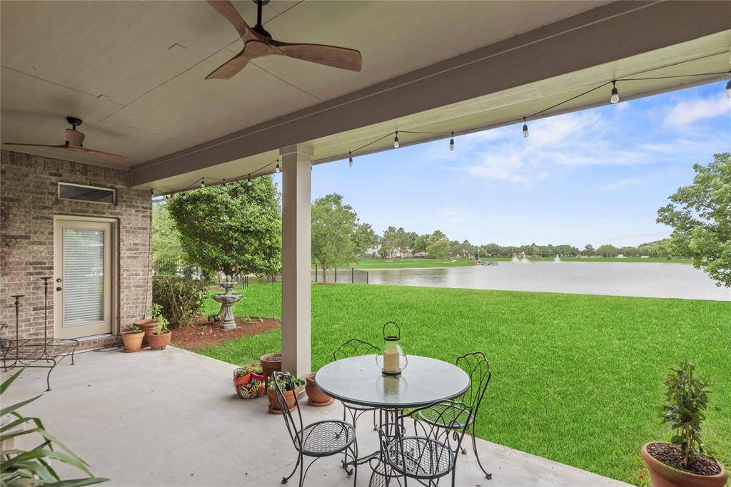 Alternate view of the covered patio overlooking a serene lake and lush green lawn.