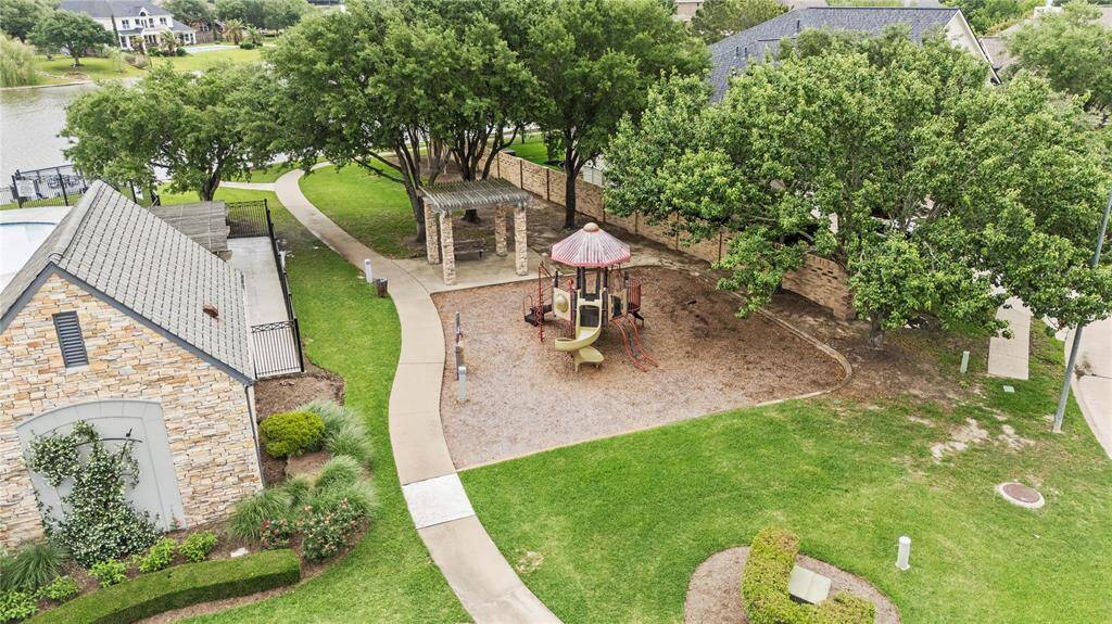 Charming community park with a playground, lush greenery, and a walking path.