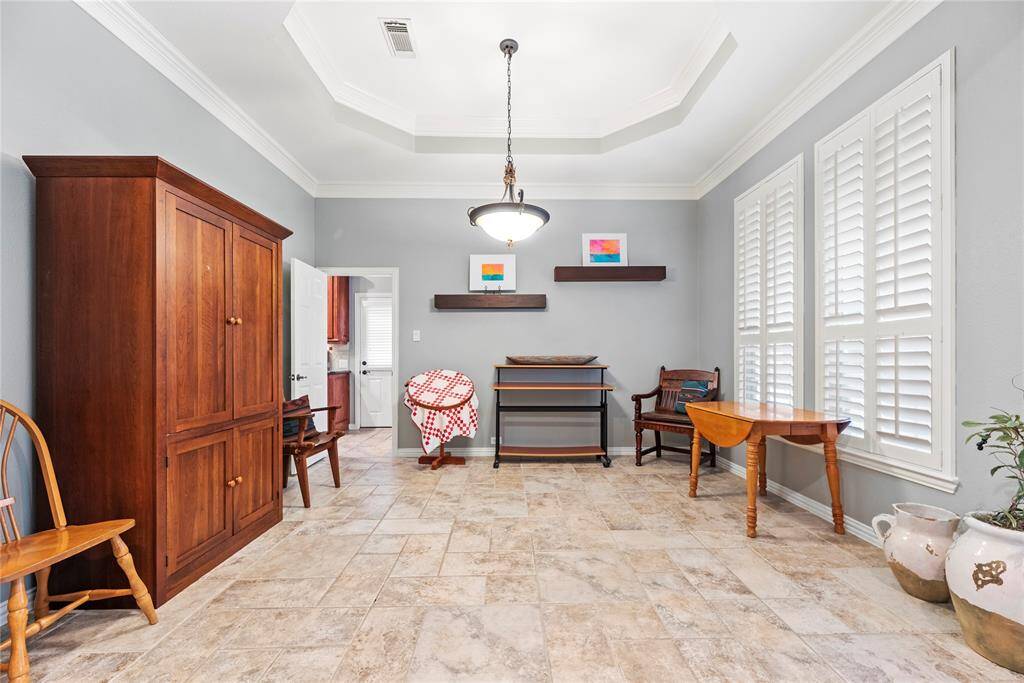 This dining room features tile flooring, large windows and plantation shutters, offering excellent natural light.