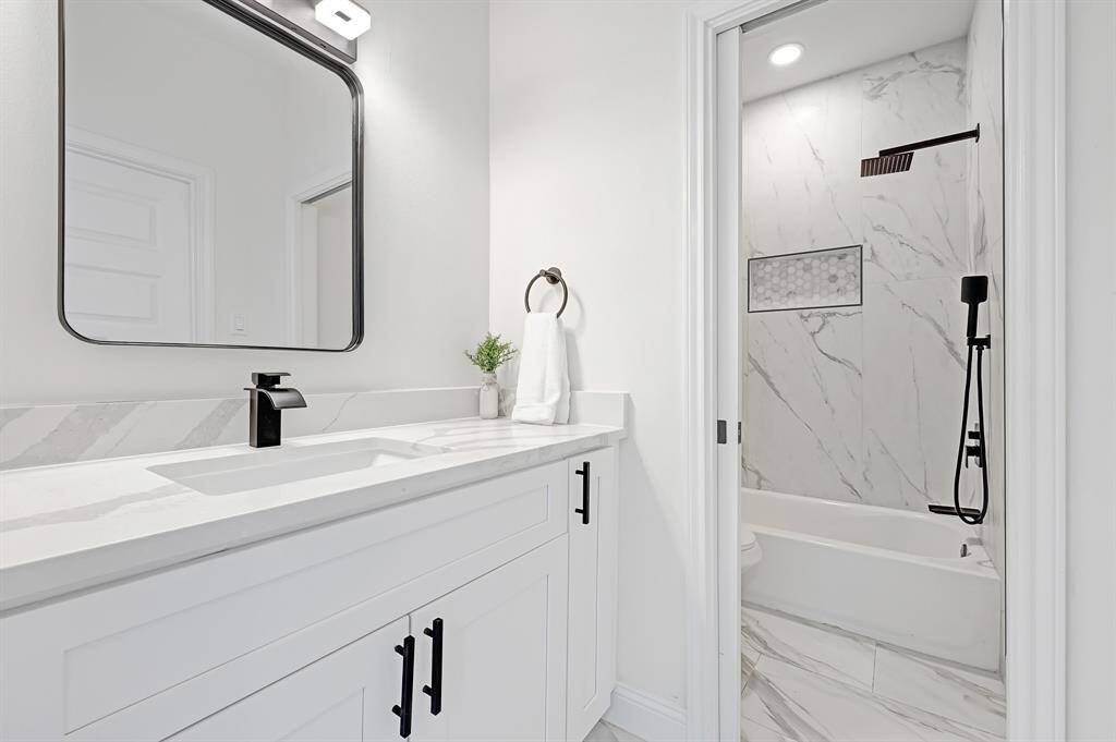 This elegant bathroom features modern fixtures, a sleek vanity, and a luxurious marble shower, creating a serene oasis for relaxation.