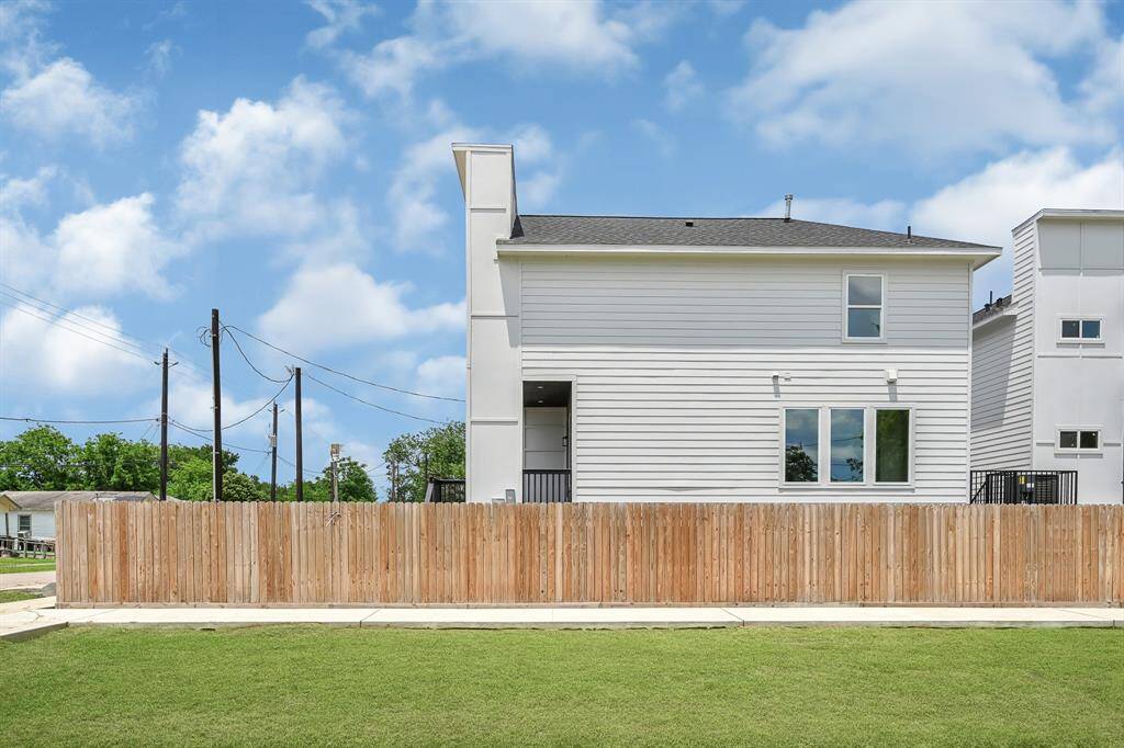 Experience modern elegance with this home's sleek side view, featuring crisp lines and a spacious fenced yard for privacy and relaxation.