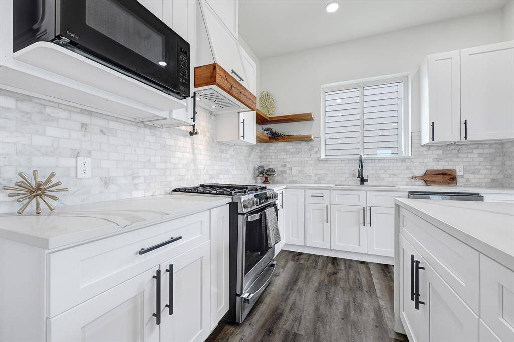 This stunning kitchen features sleek white cabinetry, modern appliances, and elegant countertops.