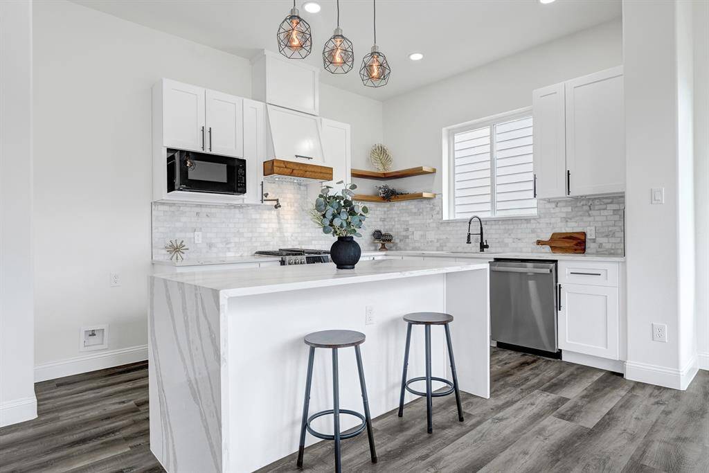 Delight in this inviting open kitchen, featuring a sleek island countertop perfect for gatherings.