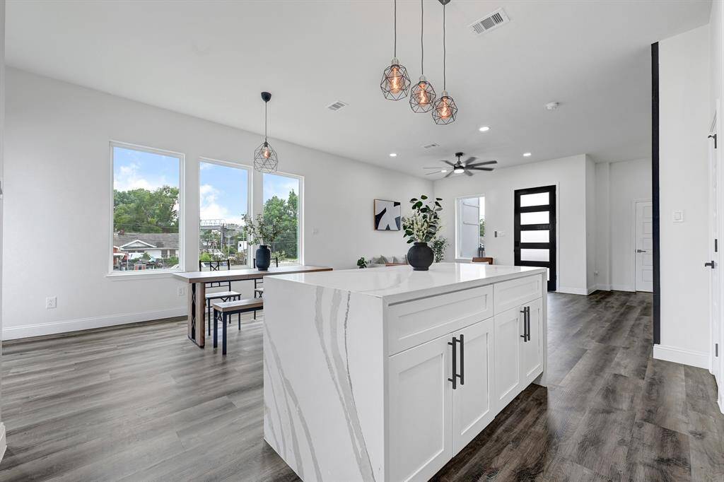 Experience modern living with this bright, open-concept space featuring sleek flooring, stylish lighting, and large windows that flood the area with natural light. Perfect for entertaining and relaxation.