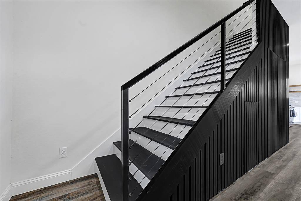 Modern, sleek staircase with black railing and wood accents, adding a stylish touch to the home's interior.