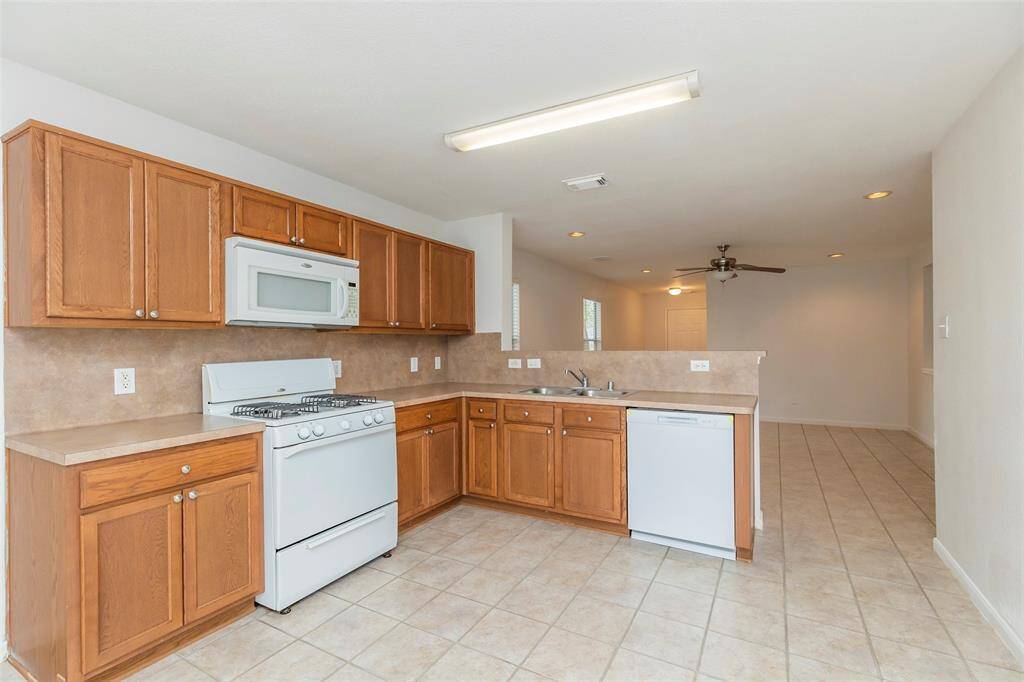Open Kitchen. Functional kitchen with ample cabinet space with white appliances.