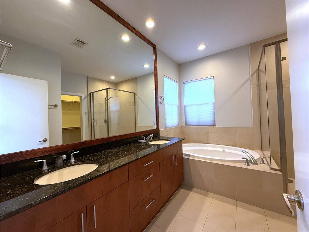 The primary bathroom offers an extended, double sink vanity with ample storage.