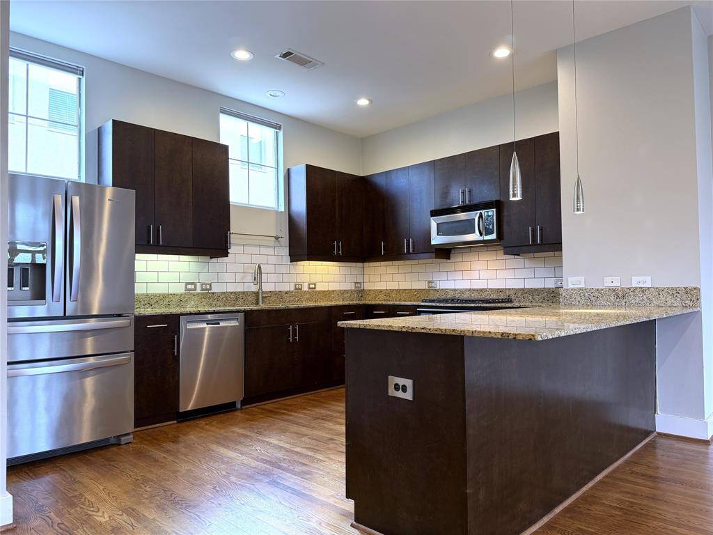 The gourmet kitchen offers a French door refrigerator with in door ice/water,  under-cabinet & pendant lighting and a Bosch brand dishwasher. The breakfast bar is large enough to accommodate several bar stools.