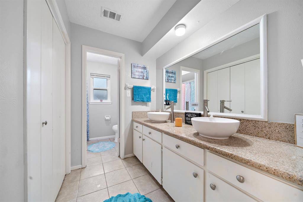Spacious secondary bathroom featuring double sinks and a versatile tub/shower combo.