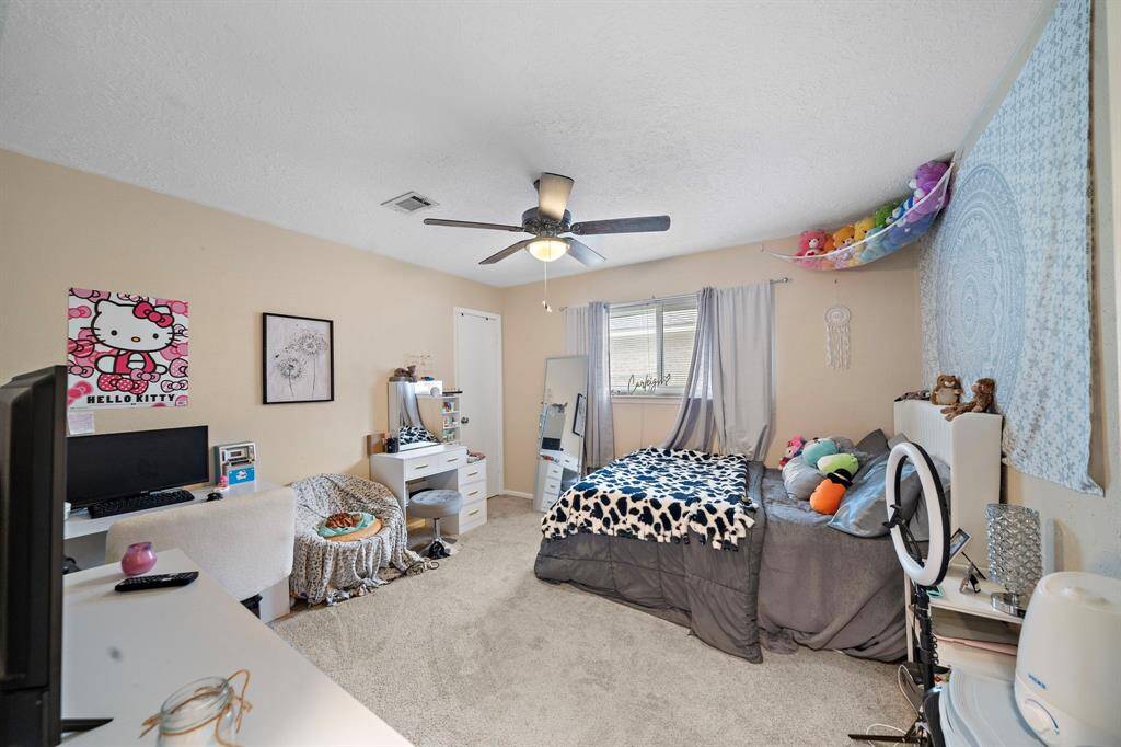 Cozy second bedroom featuring soft carpet, natural light, and ample space.