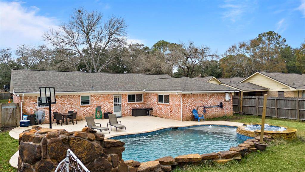 Spacious backyard featuring an inviting pool and hot tub.