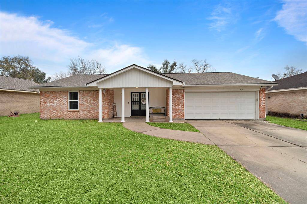 Charming brick home with a welcoming front porch and spacious two-car garage.