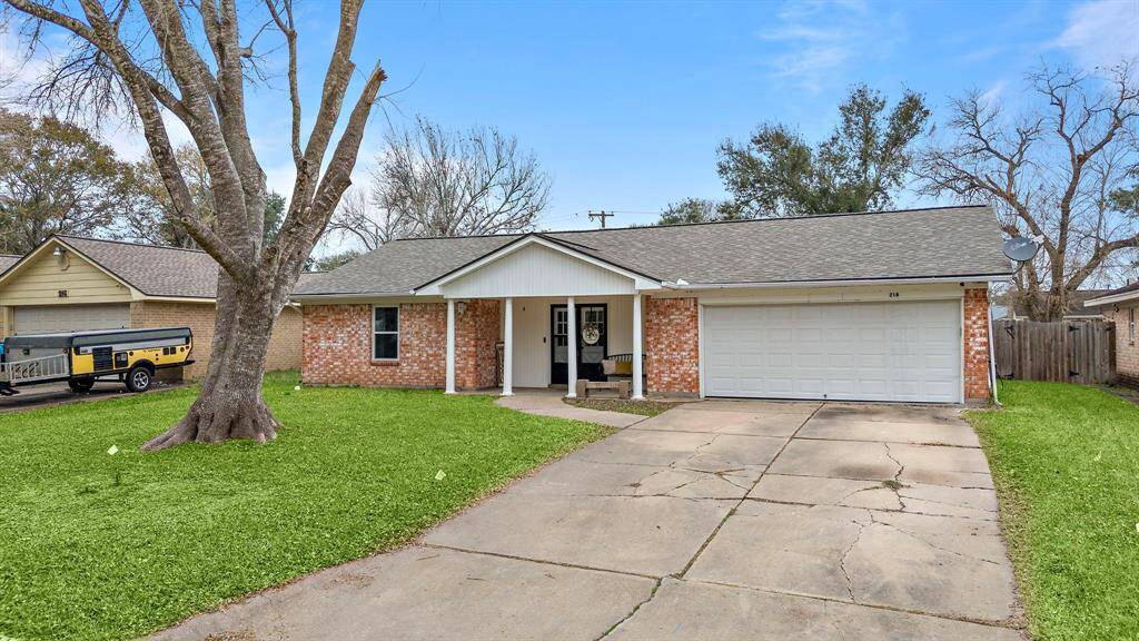 This is a charming single-story brick home with a two-car garage. It features a welcoming front porch, a spacious driveway, and a well-maintained lawn.