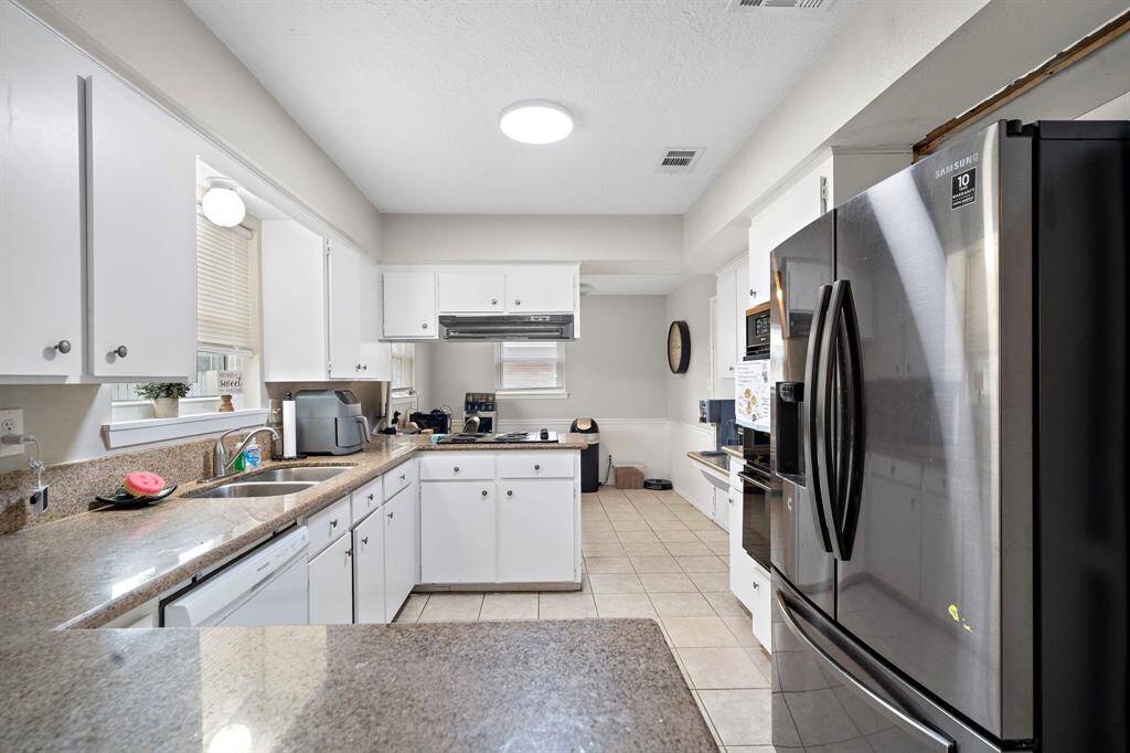 This kitchen features a modern design with white cabinetry and stainless steel appliances.