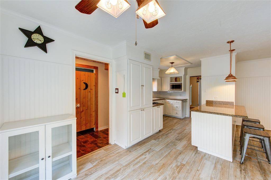 This charming kitchen and breakfast area features custom cabinetry, a granite-topped island with bar seating, and lots of natural light