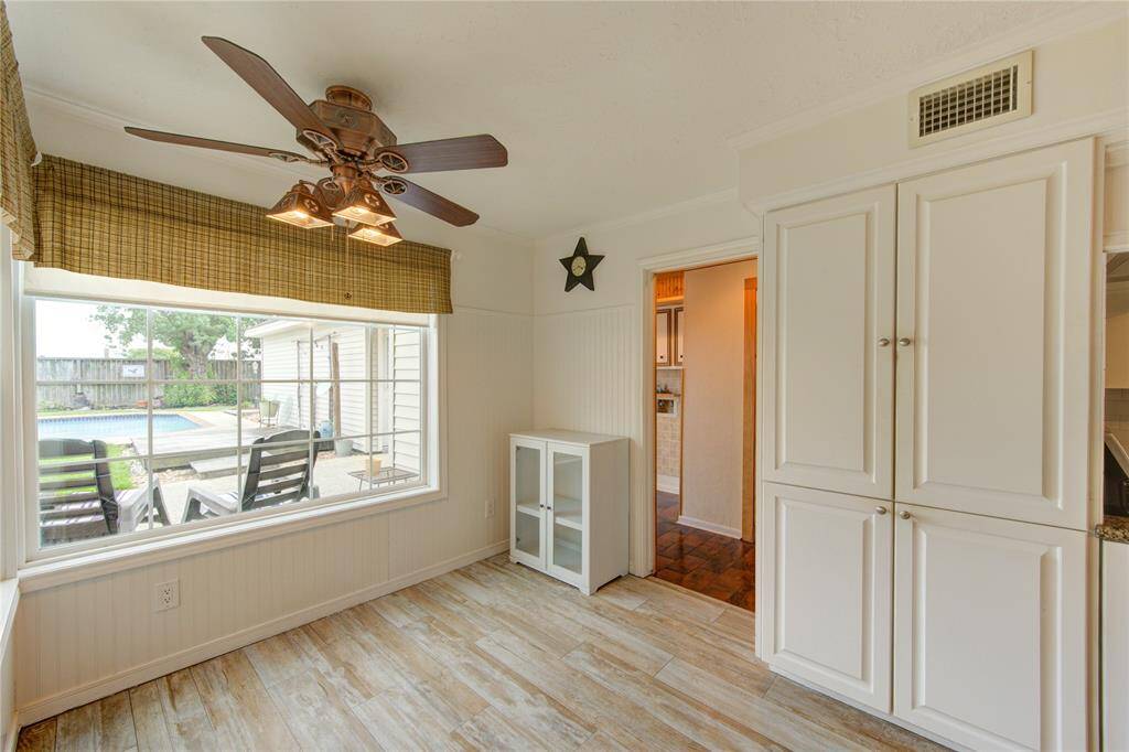 The light-filled breakfast area offers views of the backyard pool and patio through a large picture window, with ample storage and stylish wood-look tile.