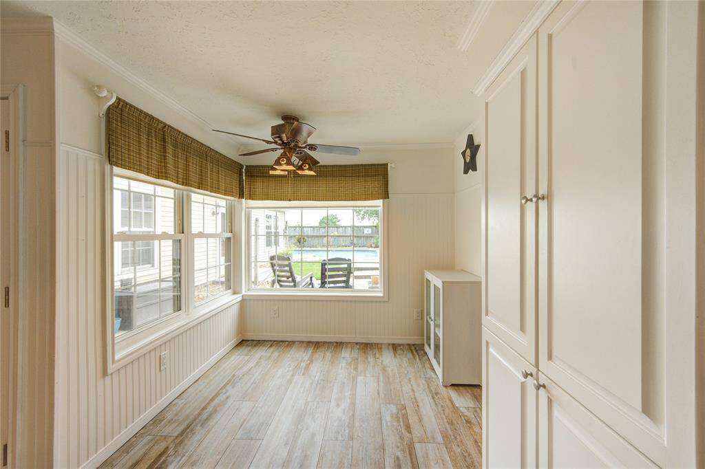 The light-filled breakfast area offers views of the backyard pool and patio through a large picture window, with ample storage and stylish wood-look tile.