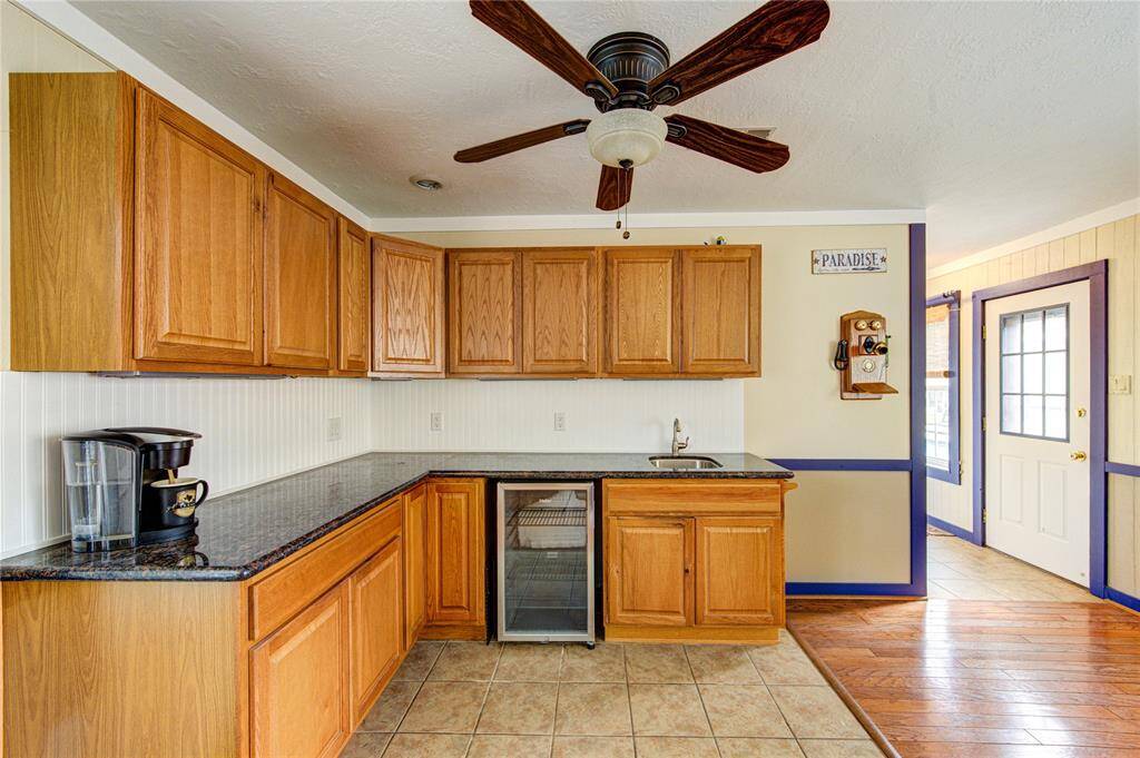 The kitchen in the next gen suite offers abundant cabinet storage, granite countertops, a beverage fridge, and a built-in sink