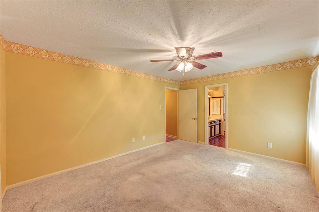 The upstairs primary bedroom—a rare and desirable layout in this area—offers generous proportions, soft natural light, and an en suite bath.