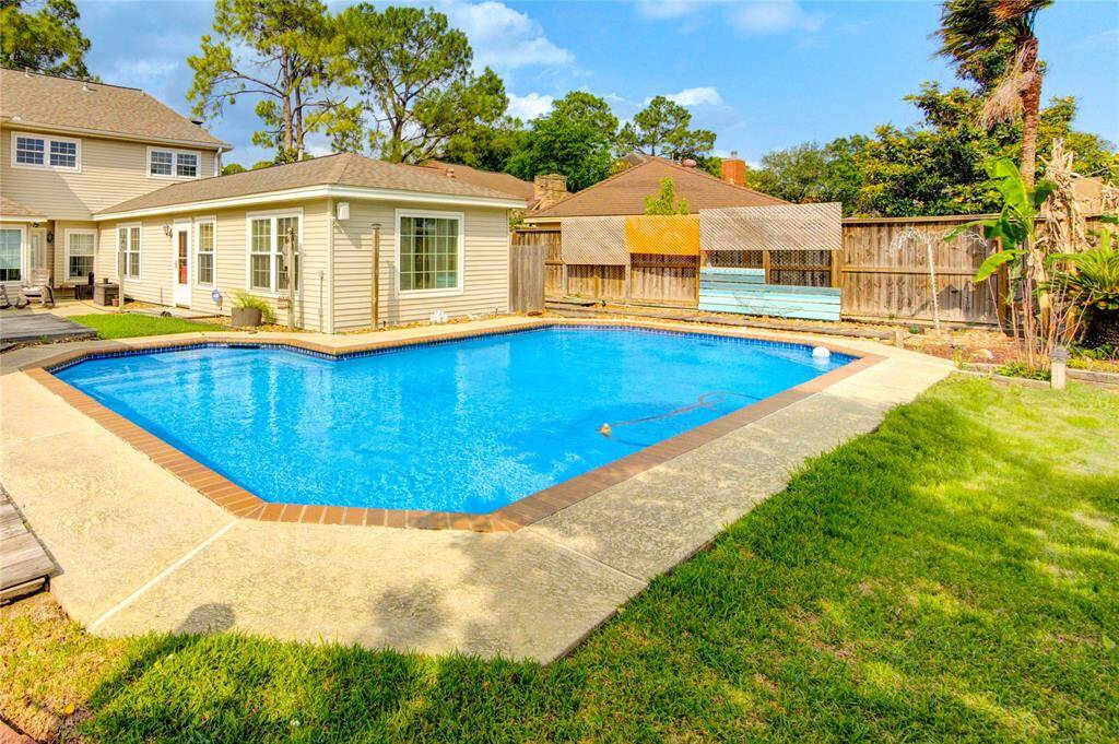 surrounded by lush landscaping the backyard is tranquil