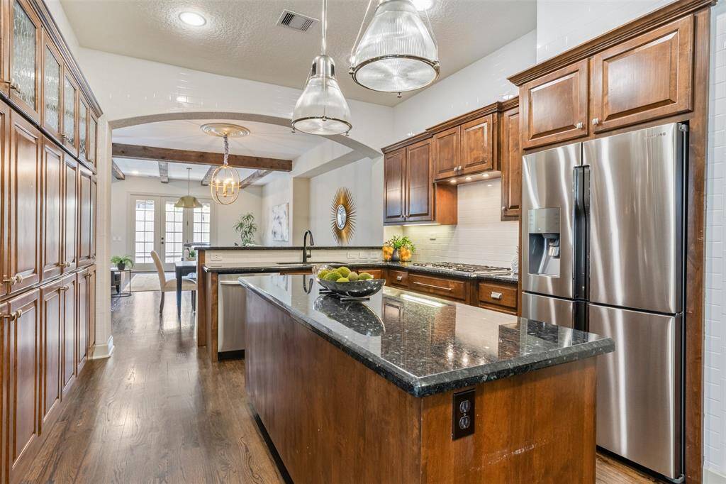Crafted for both beauty and utility, this well-appointed kitchen features rich cabinetry, granite countertops, and stainless steel appliances—all of which convey with the sale, including the refrigerator. With a generous island and open sightlines to the living and dining areas, it’s a space designed to bring everyone together.