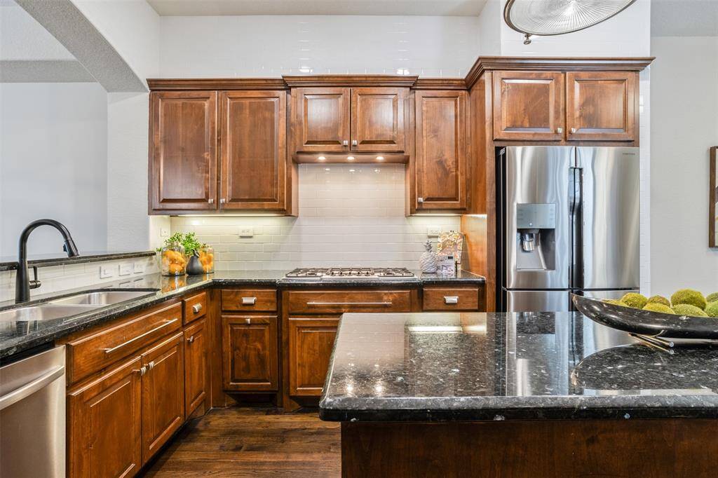 A dream for any home chef, this kitchen offers abundant counter space, custom cabinetry, and a full suite of stainless steel appliances—including a French door refrigerator that conveys with the home. The large prep island, gas cooktop, and open layout make it easy to cook, serve, and entertain with style.