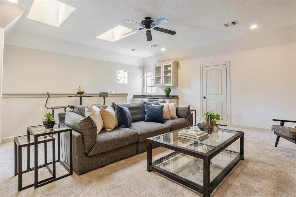 Framed by dual skylights and anchored by a built-in wet bar, this top-floor retreat blends comfort and convenience—ideal for game nights, casual lounging, or creating your own home theater experience.